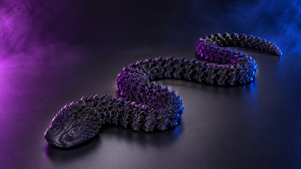 Black articulated snake fidget coiled on a dark surface under purple and blue lighting